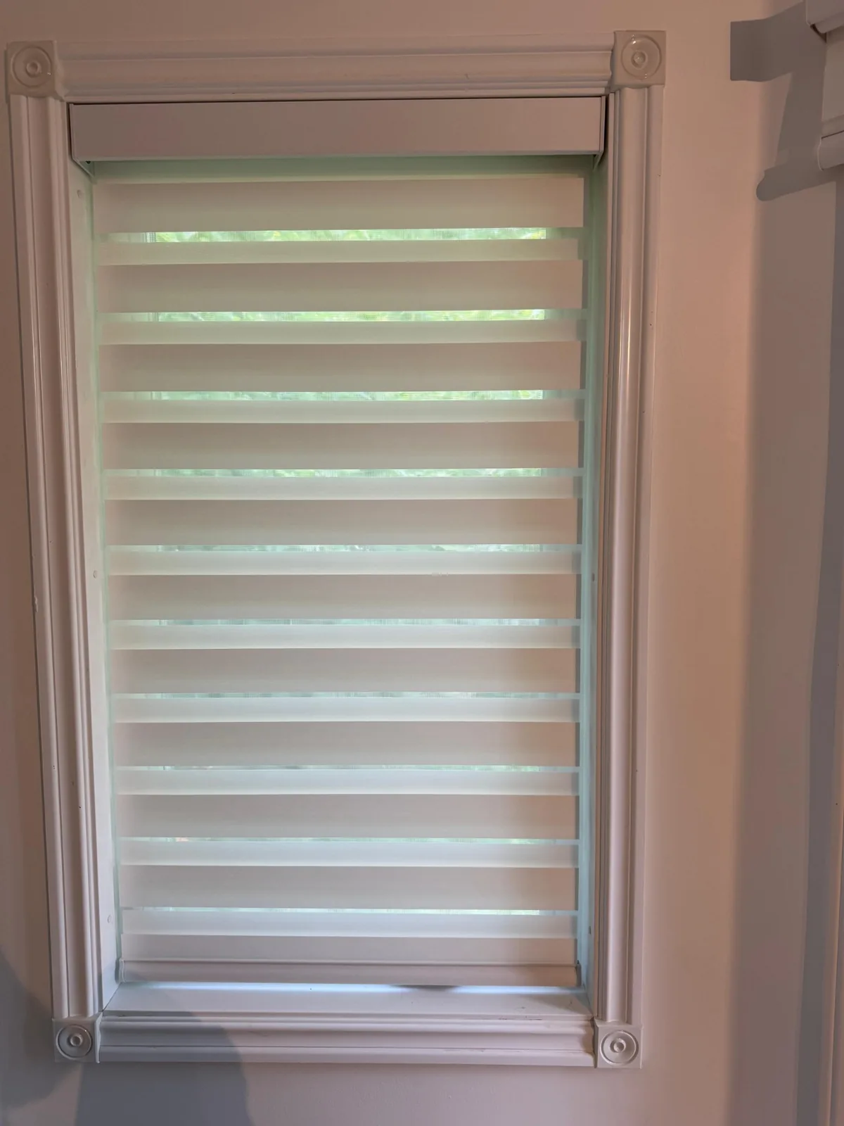 Custom layered blind fitted within detailed window trim in Mississauga
